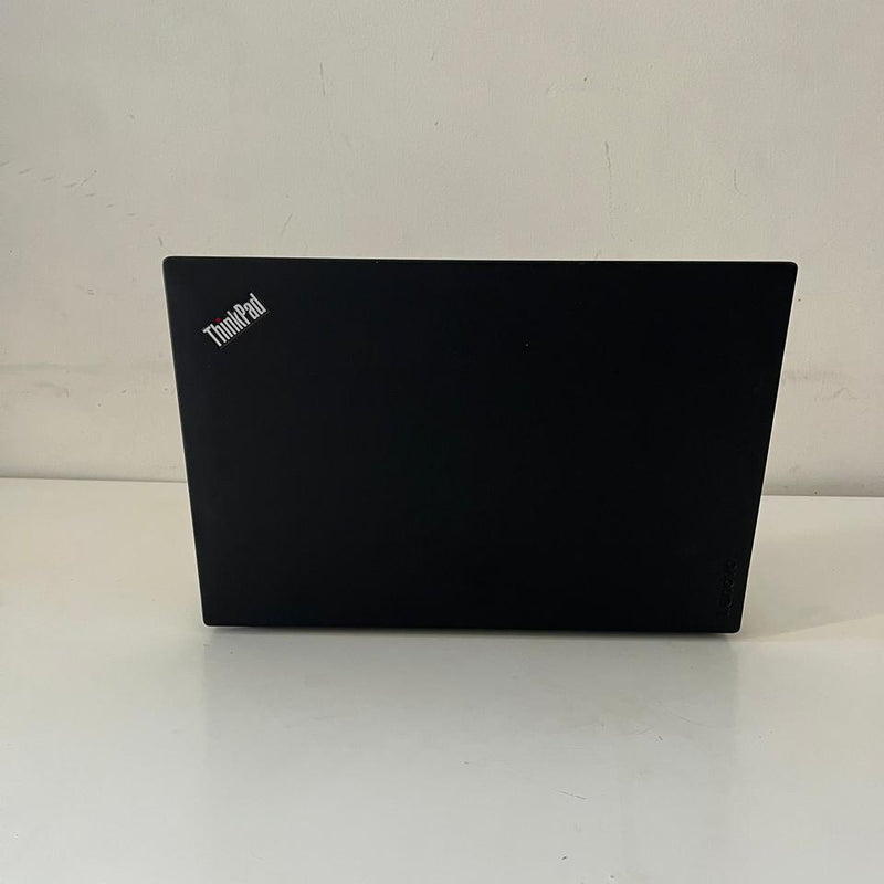 Black laptop on a white surface with a scenic wallpaper