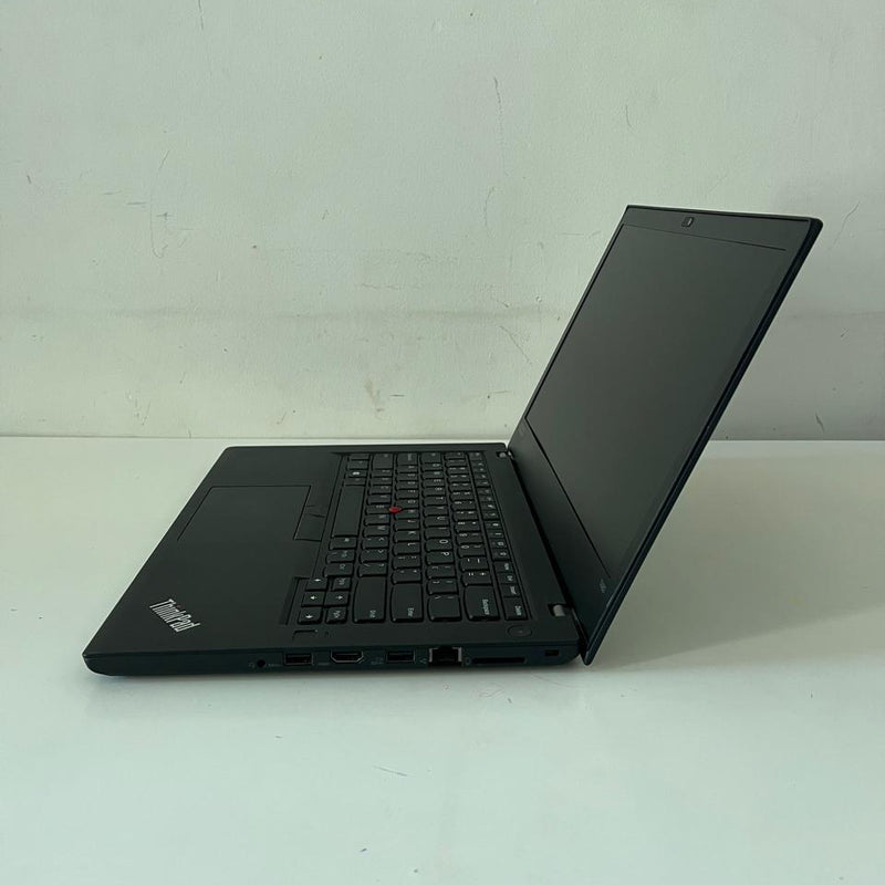 Black laptop on a white surface with a scenic wallpaper