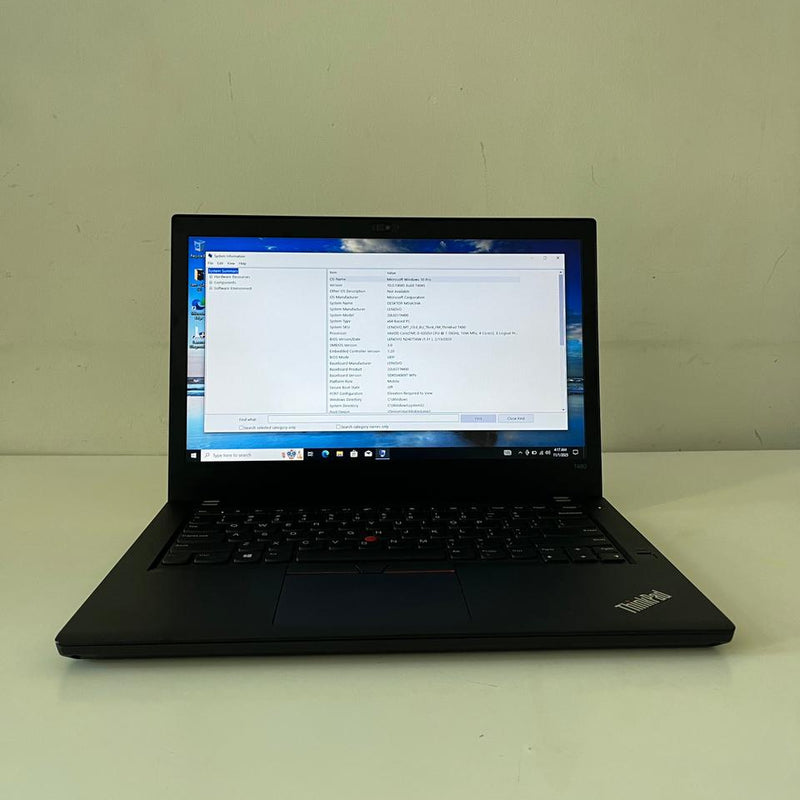 Black laptop on a white surface with a scenic wallpaper