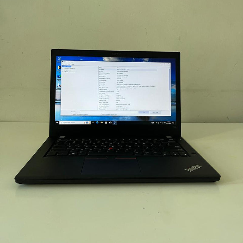 Black laptop on a white surface with a scenic wallpaper