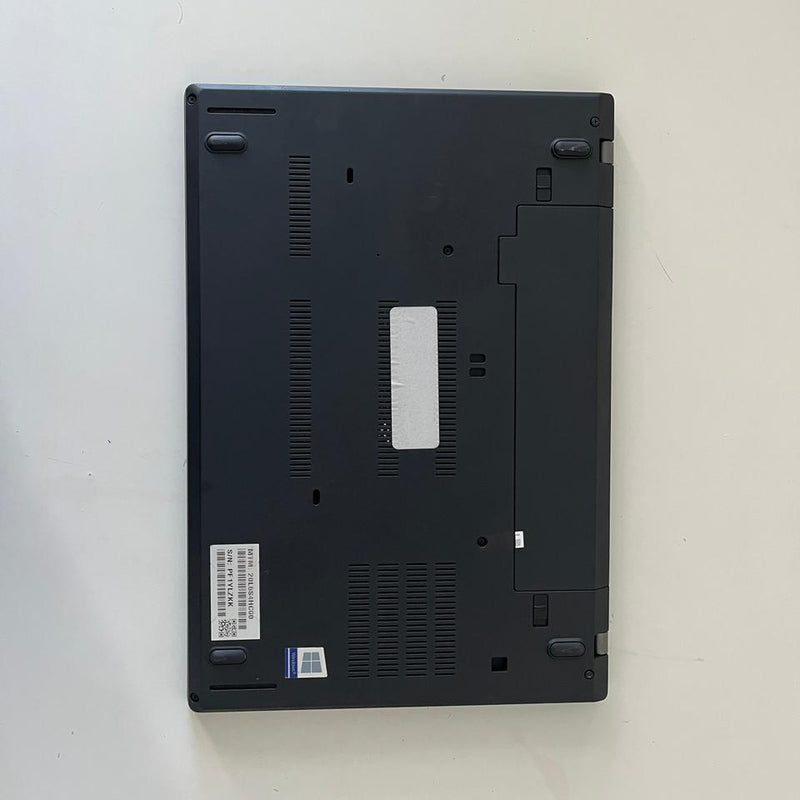 Black laptop on a white surface with a scenic wallpaper