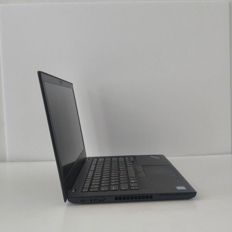 Black lenovo thinkpad laptop on a white surface with a white wall background